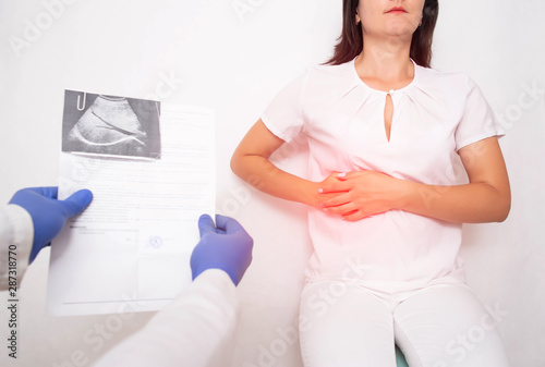 The doctor examines a girl patient with pain in the hypochondrium gall bladder. Gallbladder disease cholecystitis and biliary dyskinesia