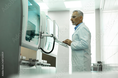 Concentrated scientist staring at screen of computer