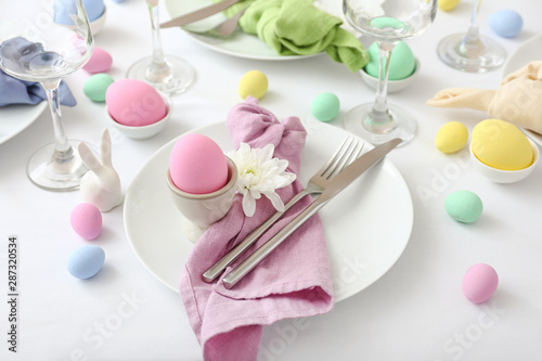 Table setting for Easter celebration on white background