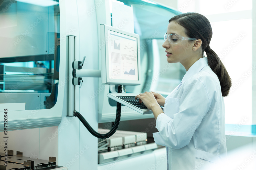 Cheerful young woman looking at working scanner Cheerful young woman looking at working scanner