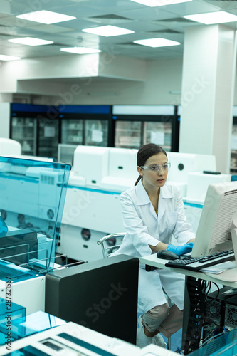 Serious young researcher testing modern equipment in lab