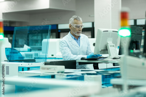 Concentrated senior researcher examining monitor of computer