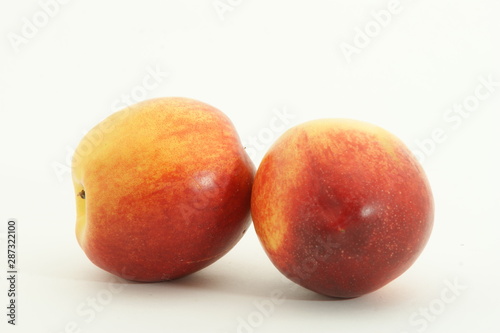 Two fresh juicy nectarines against white background