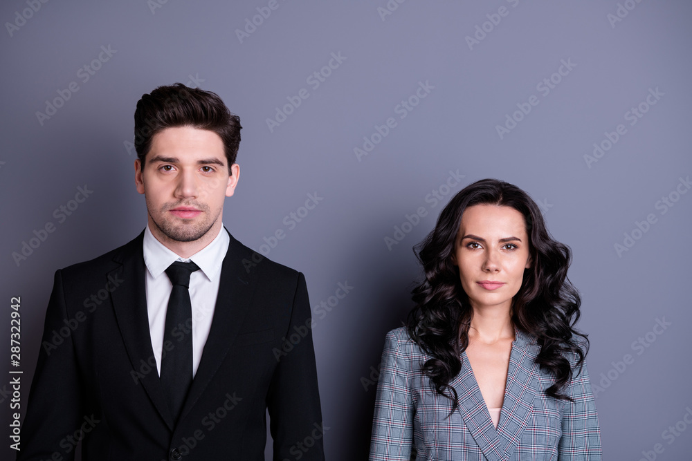 Portrait of concentrated man and woman with brunet wavy curly hair looking wearing black blazer tie jacket isolated over grey background Portrait of concentrated man and woman with brunet wavy curly hair looking wearing black blazer tie jacket isolated over grey background