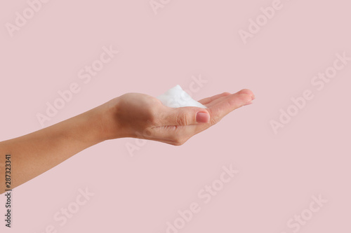 Female hand with soap on color background