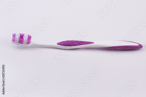 New dental tootbrush on white background. Purple tooth brush and copy space. Tool for oral hygiene.