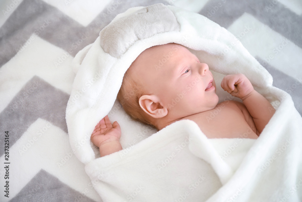 Cute little baby lying on bed