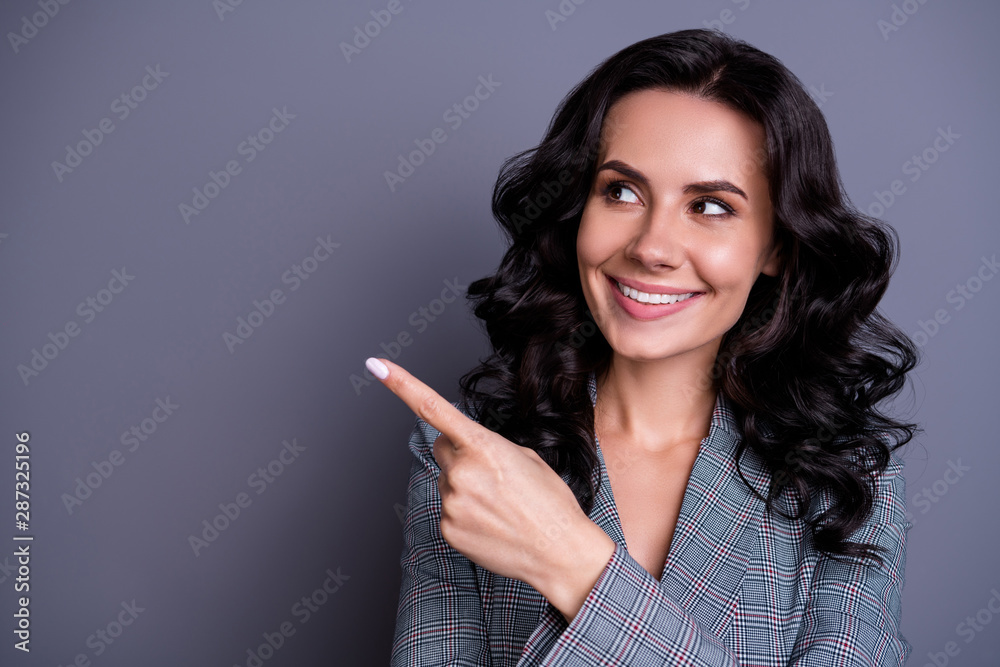 Close up photo of beautiful lady looking pointing her finger at copy space showing promo wearing suit blazer jacket isolated over grey background Close up photo of beautiful lady looking pointing her finger at copy space showing promo wearing suit blazer jacket isolated over grey background