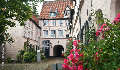 Beautiful courtyard with plants and flowers in the street of old town, Lubeck, Germany