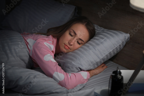 Young woman sleeping in bed at night