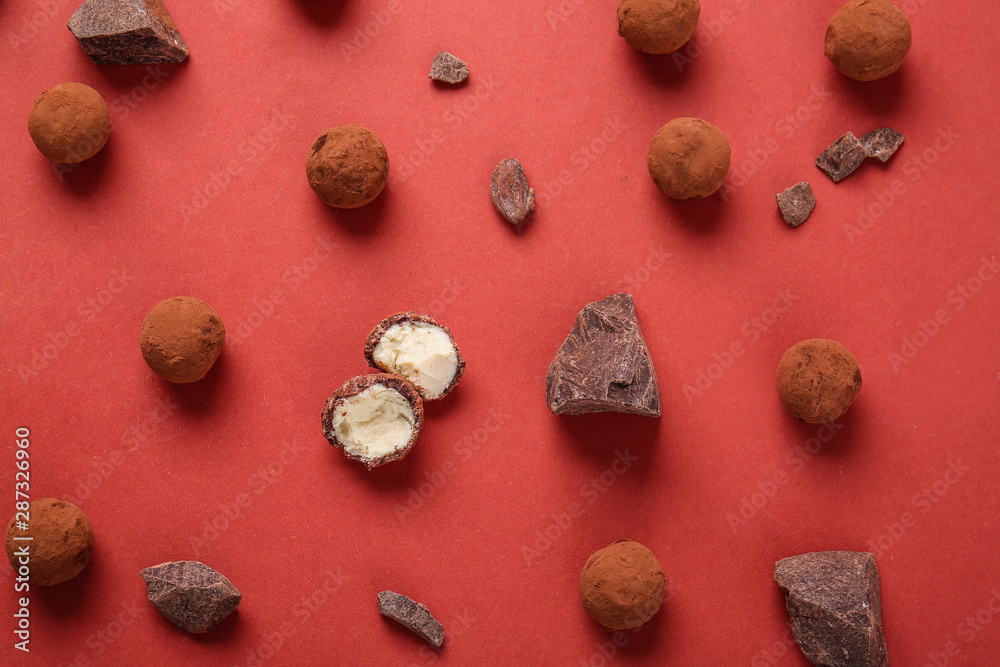 Tasty sweet truffles and chocolate on color background Tasty sweet truffles and chocolate on color background
