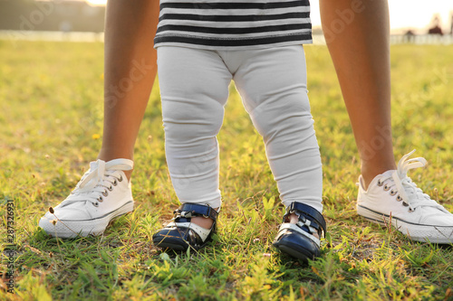 Mother teaching her little baby to walk outdoors © Pixel-Shot