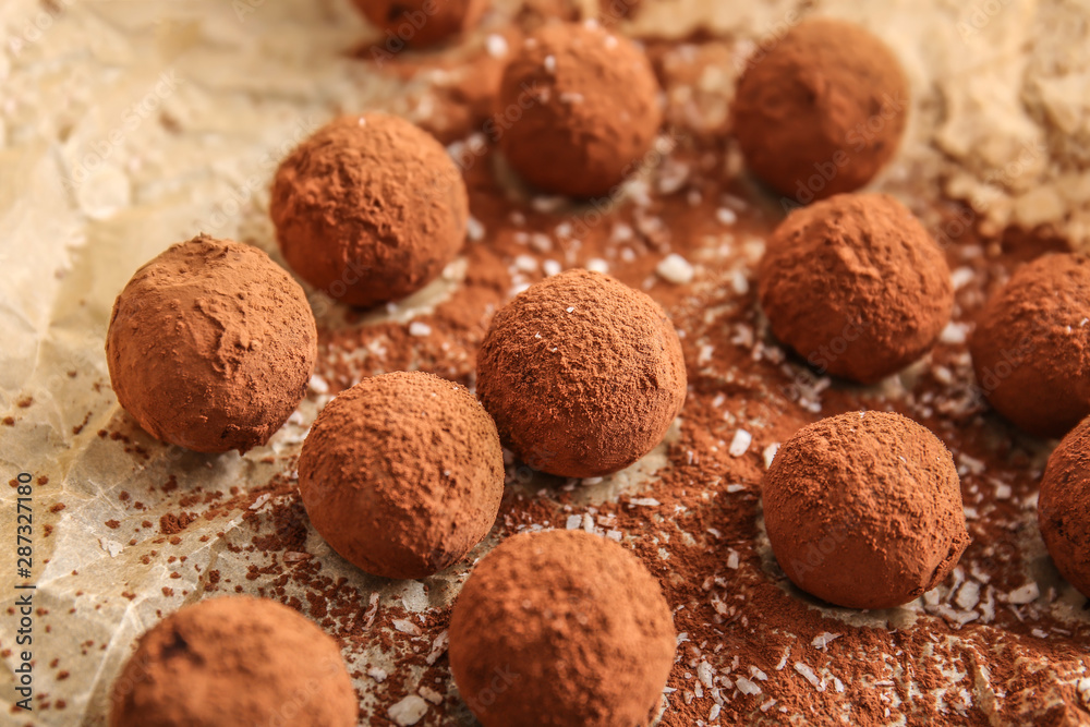 Tasty sweet truffles on parchment, closeup Tasty sweet truffles on parchment, closeup