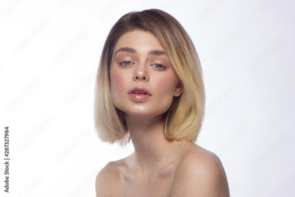 Close-up beautiful young woman face with clean perfect skin and hair. Portrait of beauty model with natural nude make up and hand near lips. Spa, skincare and wellness. Isolated on white background Close-up beautiful young woman face with clean perfect skin and hair. Portrait of beauty model with natural nude make up and hand near lips. Spa, skincare and wellness. Isolated on white background