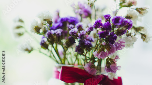 Bouquet of dried violet  pink and white wildflowers. Bright flowers lit by sunlight. Soft selective focus  macro flowers. Photo background.