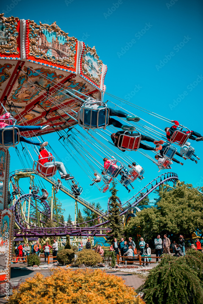 Obraz premium Colorful carrousel with kids on there. Chain swing carrousel in amusement park.