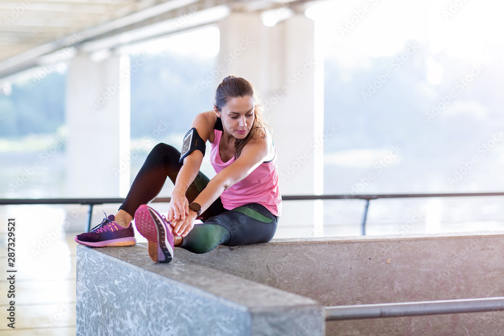 Young woman doing stretching exercise in urban area