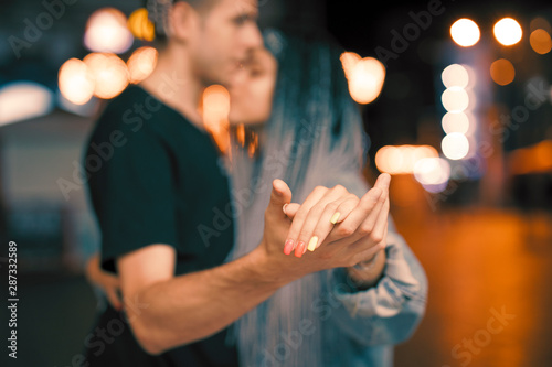 Young couple holding hands at night dancing with love