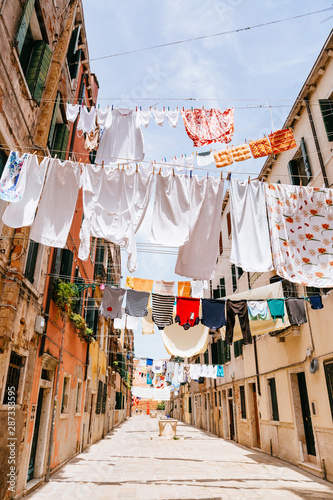 Fototapeta Naklejka Na Ścianę i Meble -  Street in Venice with linen that is dried between the houses