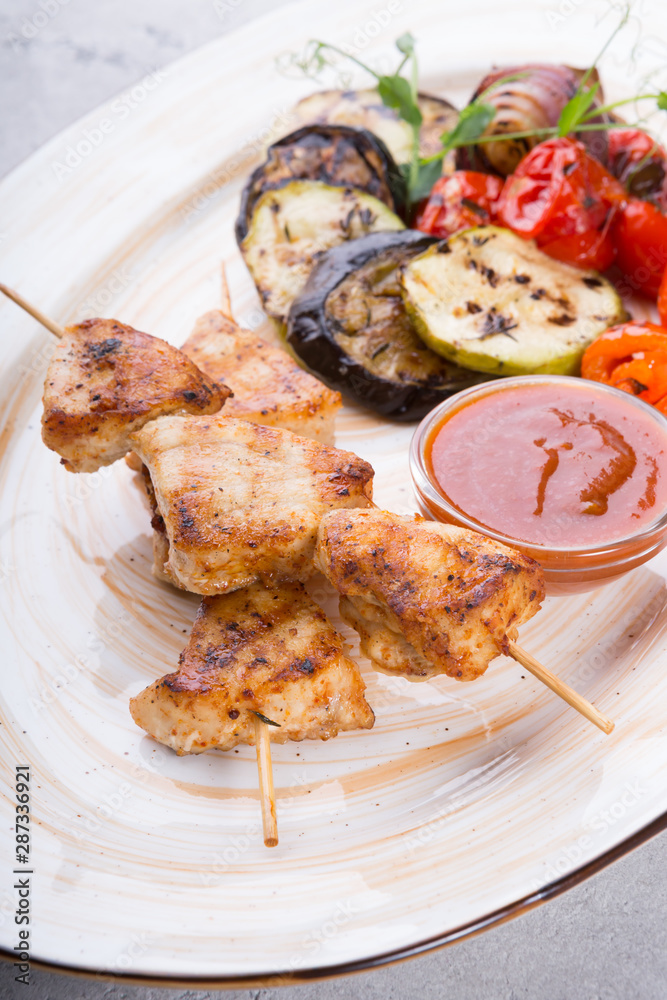 Chicken grilled on wooden skewers with vegetables
