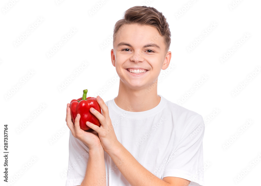 Portrait of handsome young teen boy holding fresh red pepper, isolated on white background. Happy smiling cute child with vegetables in hands. Organic natural healthy food produce. Portrait of handsome young teen boy holding fresh red pepper, isolated on white background. Happy smiling cute child with vegetables in hands. Organic natural healthy food produce.