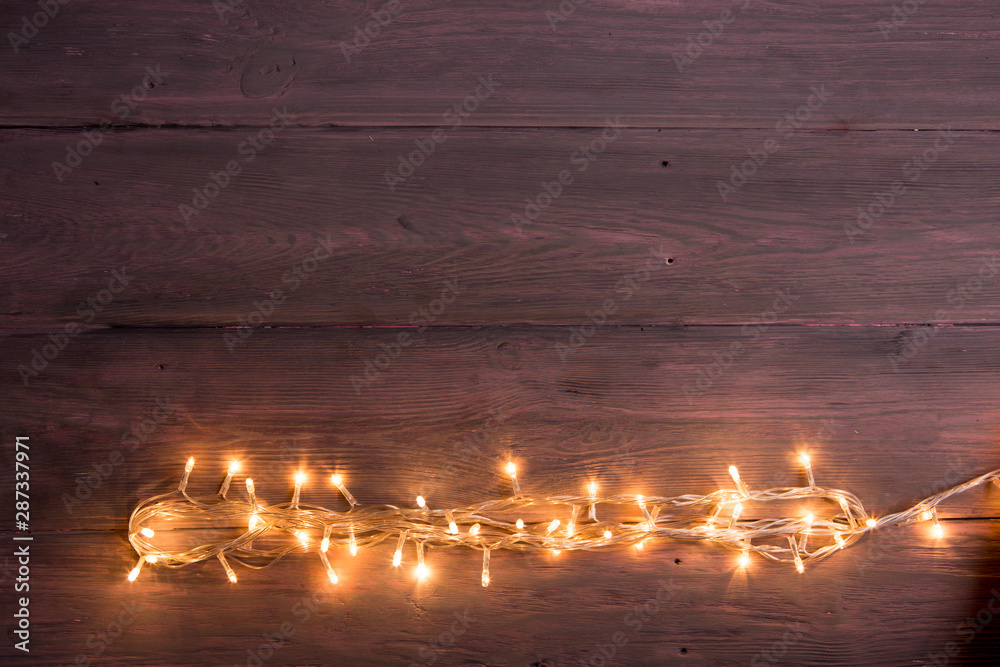 Party lights decoration. Wooden background with christmas lights garland