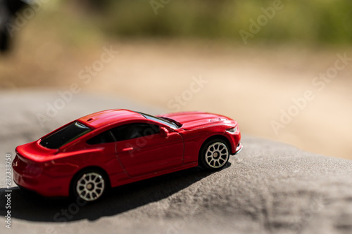 Red toy car on a blurred background. Selective focus. Travel concept.