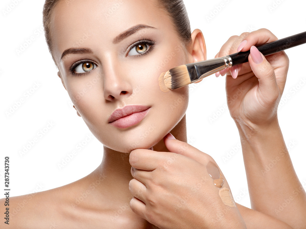 Makeup artist applying liquid tonal foundation on the face Makeup artist applying liquid tonal foundation on the face