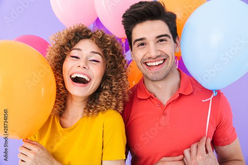 Photography Image of happy couple man and woman smiling at camera while standing with multic