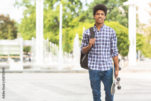 Handsome male teenager with skateboard posing to camera © Prostock-studio