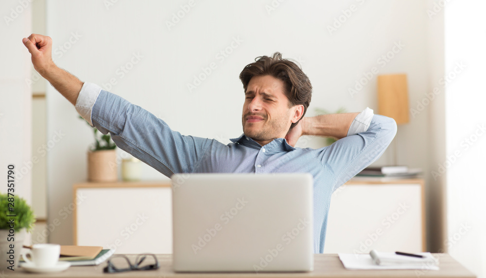 Young Man Stretching Hands Woking On Laptop At Home Young Man Stretching Hands Woking On Laptop At Home