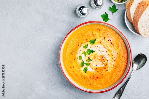 Photos Carrot and pumpkin cream soup with parsley on gray stone background