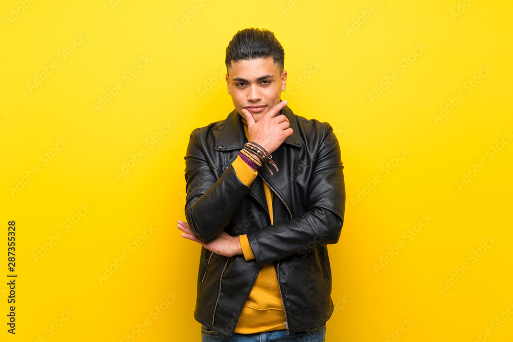 Young man over isolated yellow background thinking Young man over isolated yellow background thinking