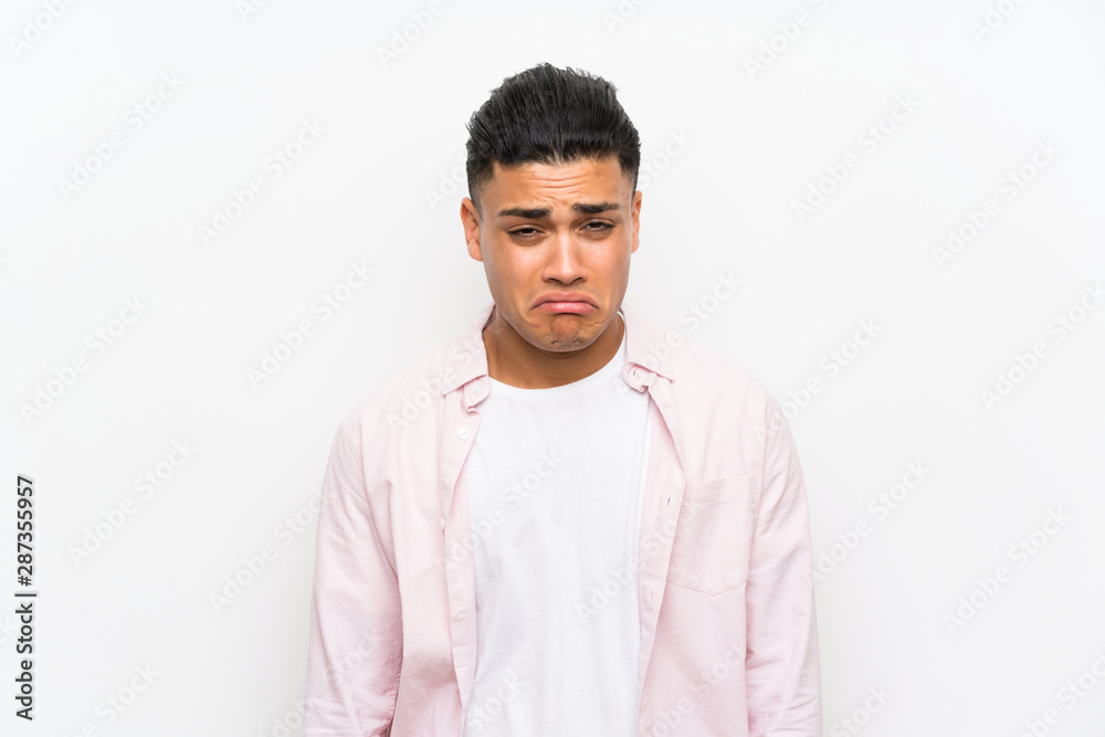 Young man over isolated white wall sad Young man over isolated white wall sad
