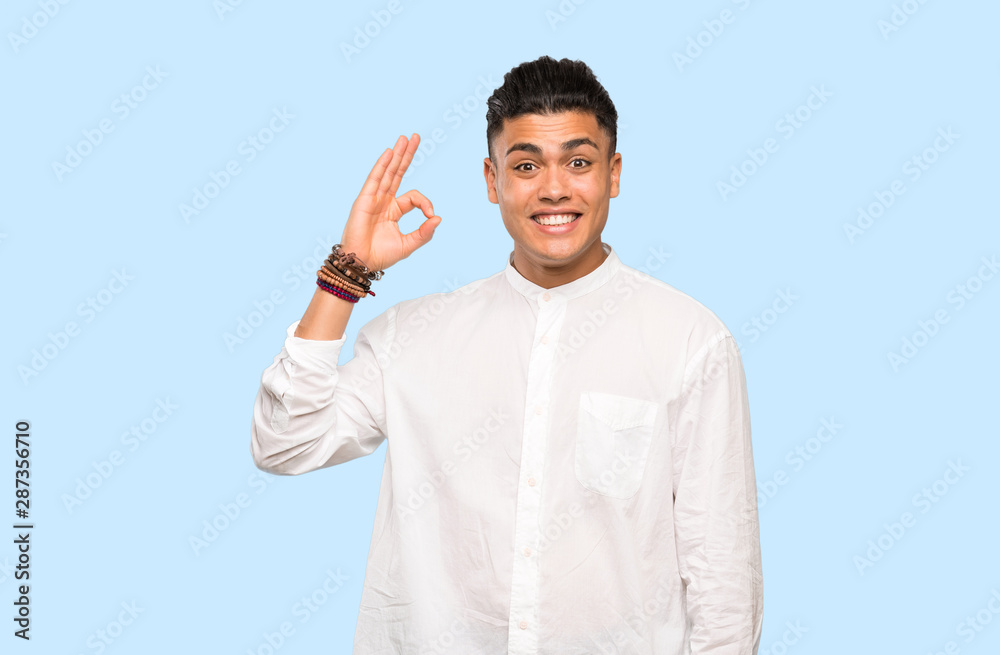 Young man surprised and showing ok sign on colorful background Young man surprised and showing ok sign on colorful background