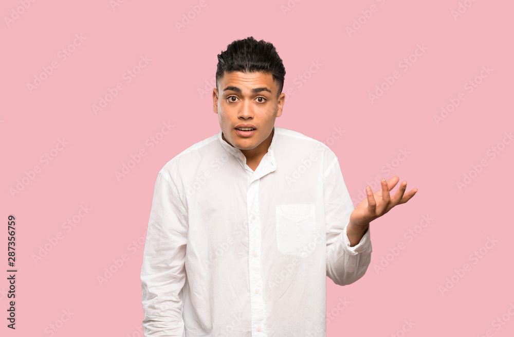Young man making doubts gesture on colorful background Young man making doubts gesture on colorful background
