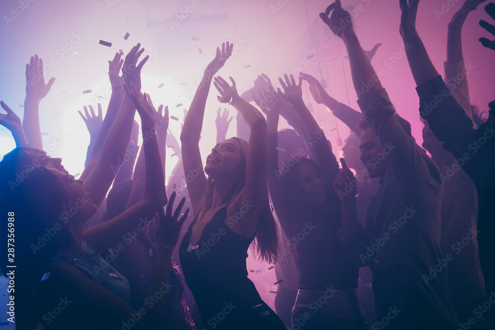 Photo of many birthday event people dancing purple lights confetti flying enjoy nightclub hands raised formal wear outfit - obrazy, fototapety, plakaty 