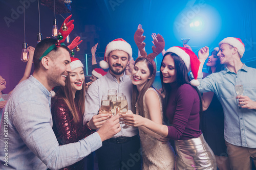 Portrait of nice attractive stylish cheerful cheery positive funny ladies and guys having fun rest relax tradition winter vacation December at modern luxury fogged lights nightclub