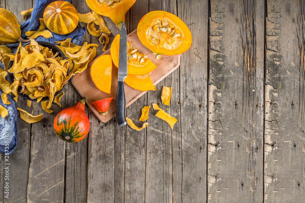 Sun-dried organic pumpkin slices, hokkaido butternut squash chips, on old rustic wooden background with fresh sliced pumpkin Sun-dried organic pumpkin slices, hokkaido butternut squash chips, on old rustic wooden background with fresh sliced pumpkin
