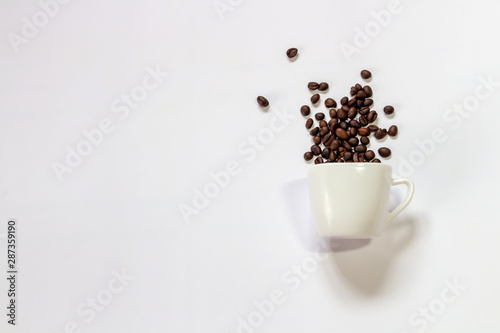 Coffee beans in a white cup on a white background