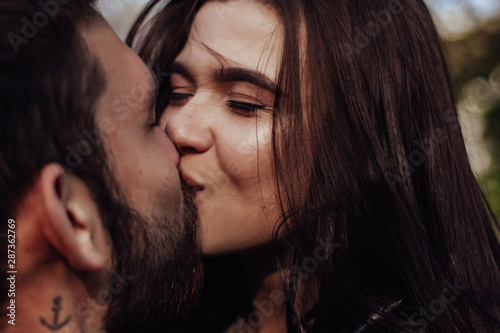 Head shot of young affectionate romantic couple in love. Close up portrait of attractive brunette girl and guy with eyes closed, close to each other. Concept of first kiss, tenderness and amorousness