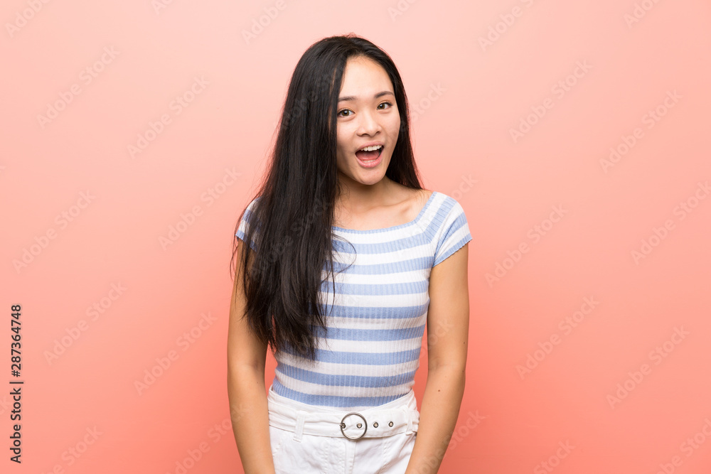 Obraz premium Teenager asian girl over isolated pink background with surprise facial expression
