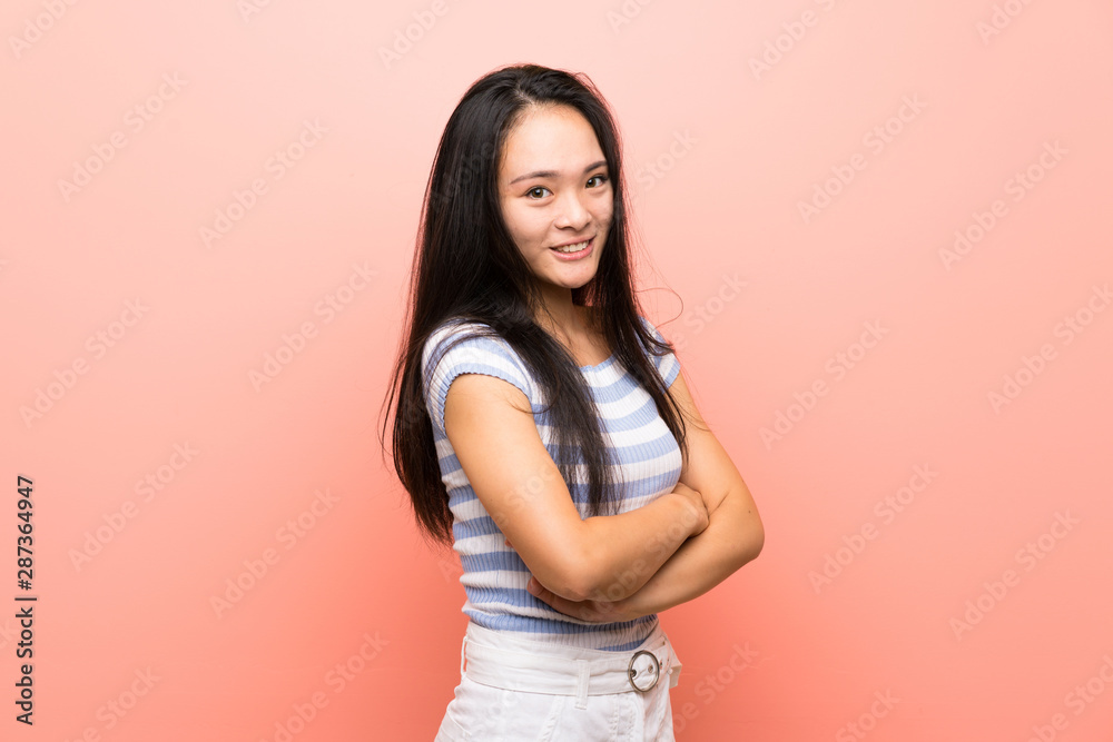 © luismolinero - Teenager asian girl over isolated pink background with arms crossed and looking forward © luismolinero - Teenager asian girl over isolated pink background with arms crossed and looking forward