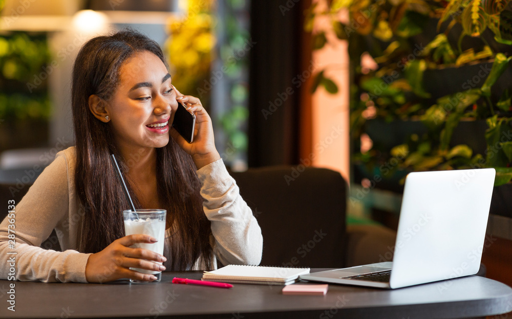 Cheerful teen girl talking on cellphone at cafe Cheerful teen girl talking on cellphone at cafe
