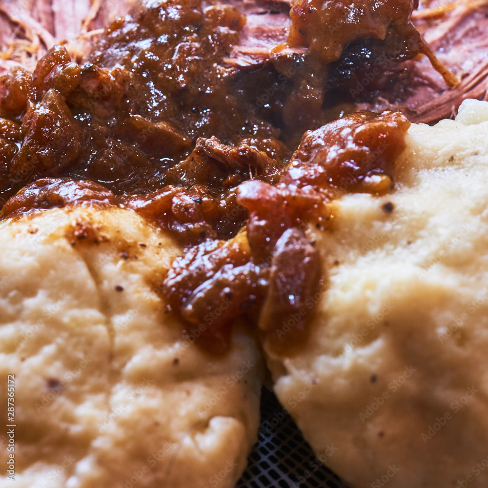 Handmade potato dumplings with dark brown onion sauce, close-up view Handmade potato dumplings with dark brown onion sauce, close-up view