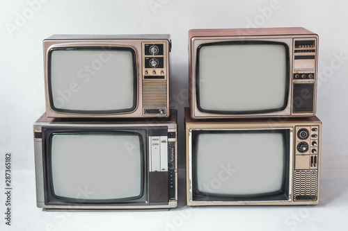 Retro televisions pile on floor in white room. vintage old tv style