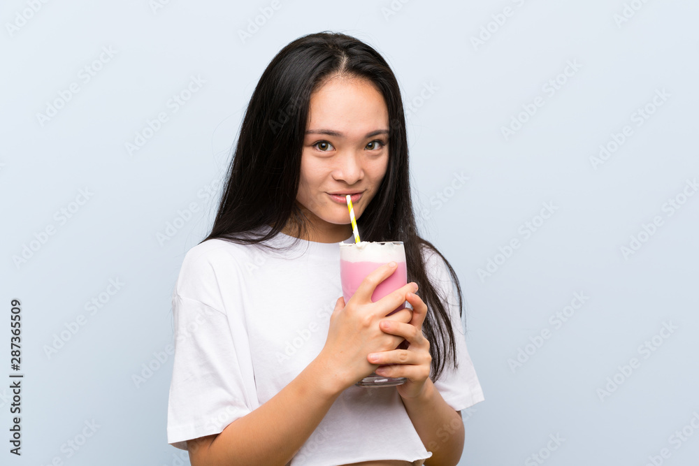 Teenager asian girl holding a strawberry milkshake Teenager asian girl holding a strawberry milkshake