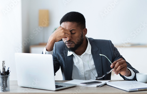 African american businessman tired of long time work on laptop photo