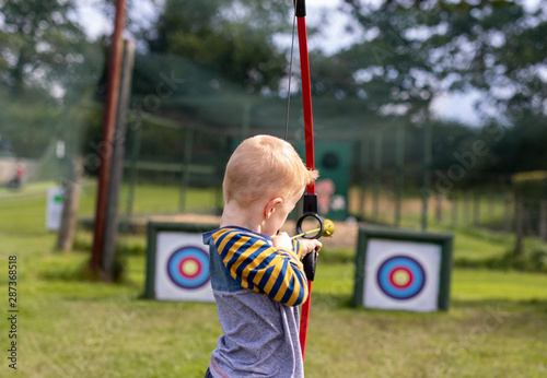 little boy aiming at archery target