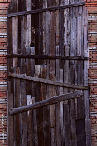 Boarded up windows on a brick wall. Abstract wooden background. Brick wall and wood panels.